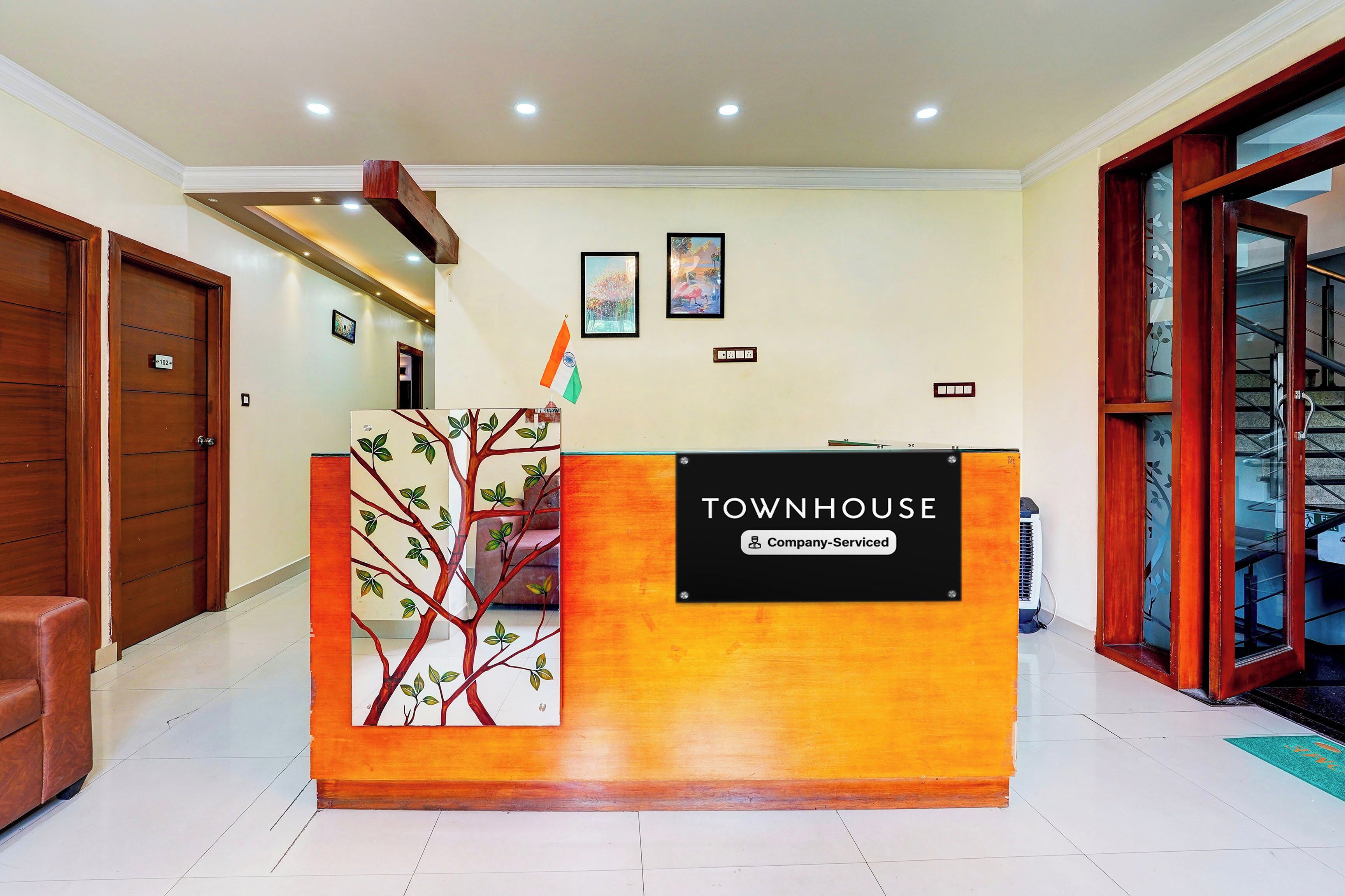 A reception desk with a sign reading 'TOWNHOUSE Company Serviced' and a flag on top.