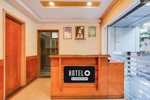 Et hotelreceptionsdisken med et skilt der står 'HOTELO' og en virksomhedsserviceret meddelelse.