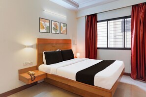 A hotel room with a bed, bedside table, lamp, and artwork on the wall. - Hotel O Thimmaiah Rd Rajajinagar (Bangalore)