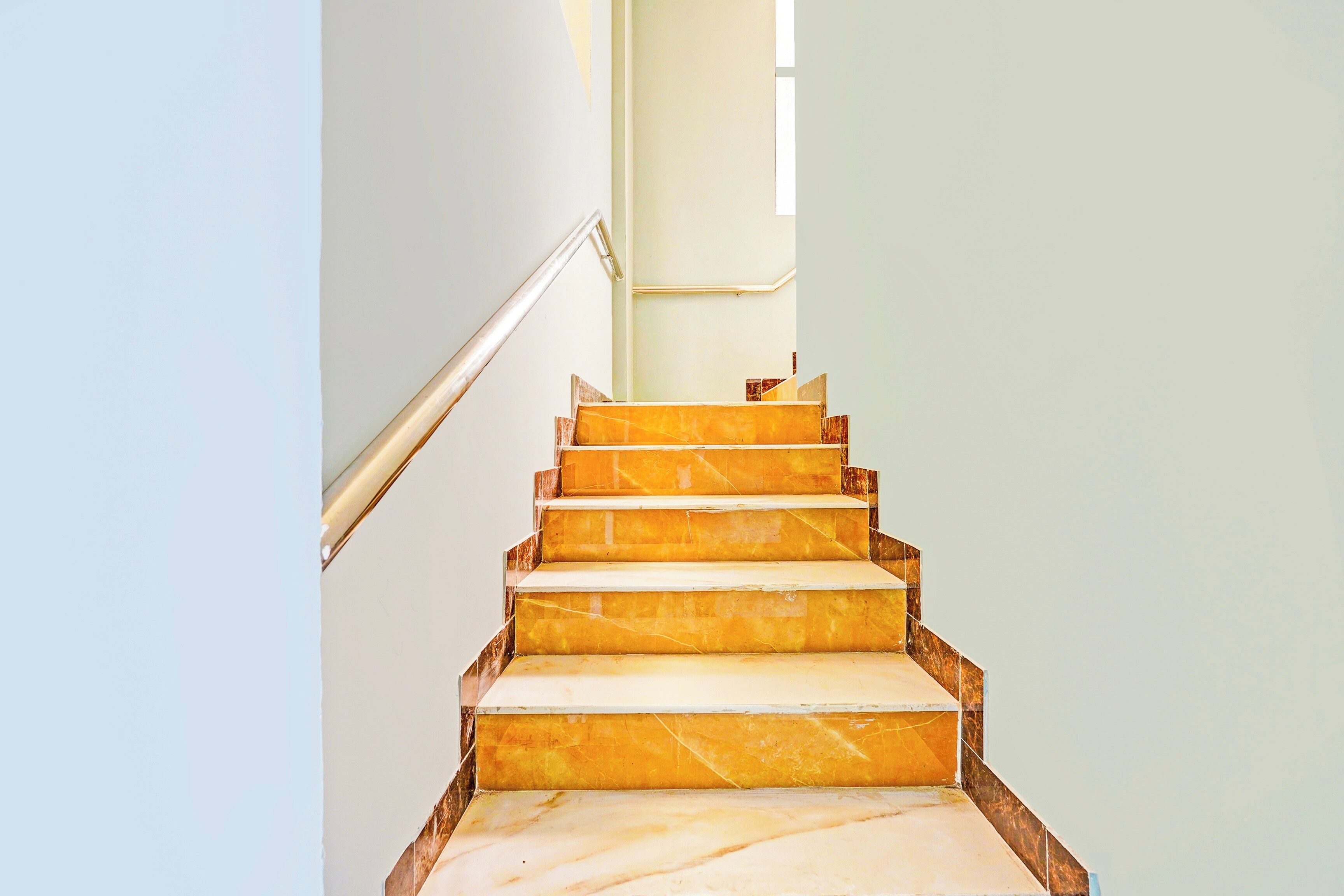 Un escalier avec des marches en marbre menant à un palier.