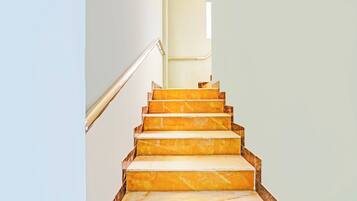 Un escalier avec des marches en marbre menant à un palier.