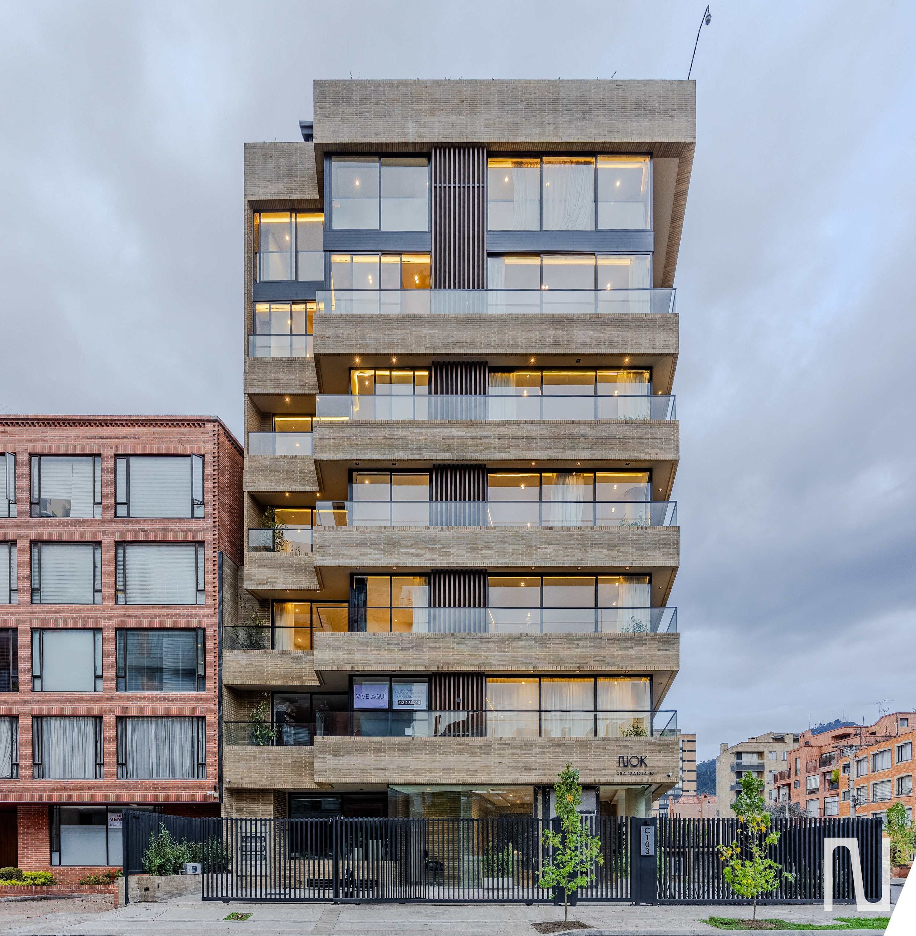 Un edificio de varios pisos con un diseño arquitectónico moderno, que cuenta con balcones y ventanas amplias.
