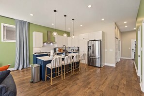 A modern kitchen with a central island, stainless steel appliances, and pendant lighting. - Retro Retreat Hot Tub Firepit Near Lucas Oil (Indianapolis)
