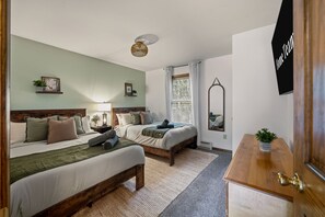 A bedroom with two beds, a bedside table, a mirror, and a wall-mounted TV. - Poconos Retreat Sauna Hot Tub Fire Pit Games (Lake Harmony)
