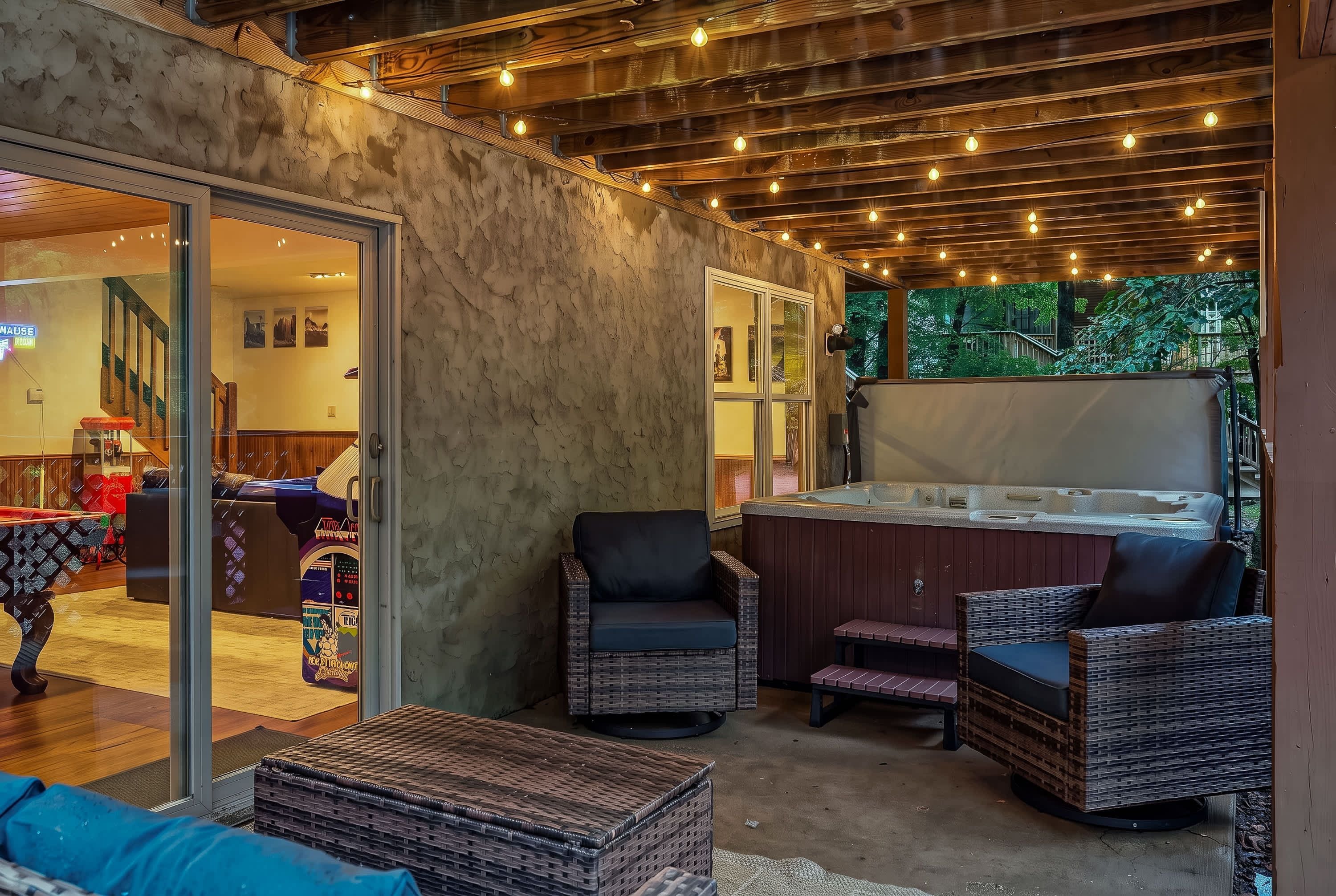 A cozy outdoor seating area with wicker furniture, a hot tub, and a glass door leading to an indoor space.
