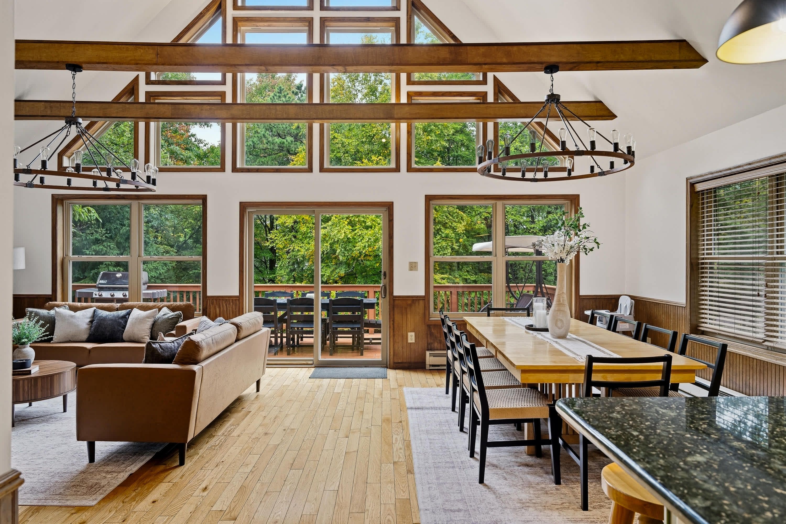 A spacious interior with a high ceiling, large windows, and a dining area.