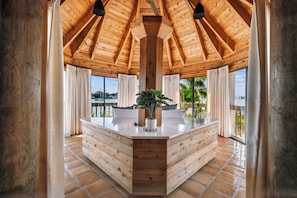 A wooden interior with a central island, large windows, and a view of the outdoors. - Private Island Oasis Pool Dock Boat-in Only (Longboat Key)