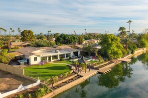 Ein Wohngebiet mit einem Haus, das eine Terrasse, einen Pool und einen Blick auf einen Fluss bietet.