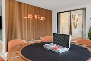 A room with a round table, a neon sign reading 'Lakintit Easy', and a wall with vertical wooden slats. - Lakin It Easy Luxe Waterfront Oasis Sleeps 16 (Mesa)