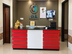 Una mesa de recepción con un logotipo, un calendario y una cámara de seguridad.