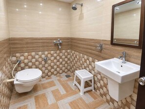 A bathroom with a toilet, sink, and shower. - Classic Hotel DI Regency (Bathinda)