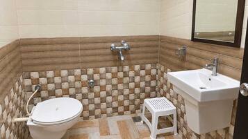 A bathroom with a toilet, sink, and shower.