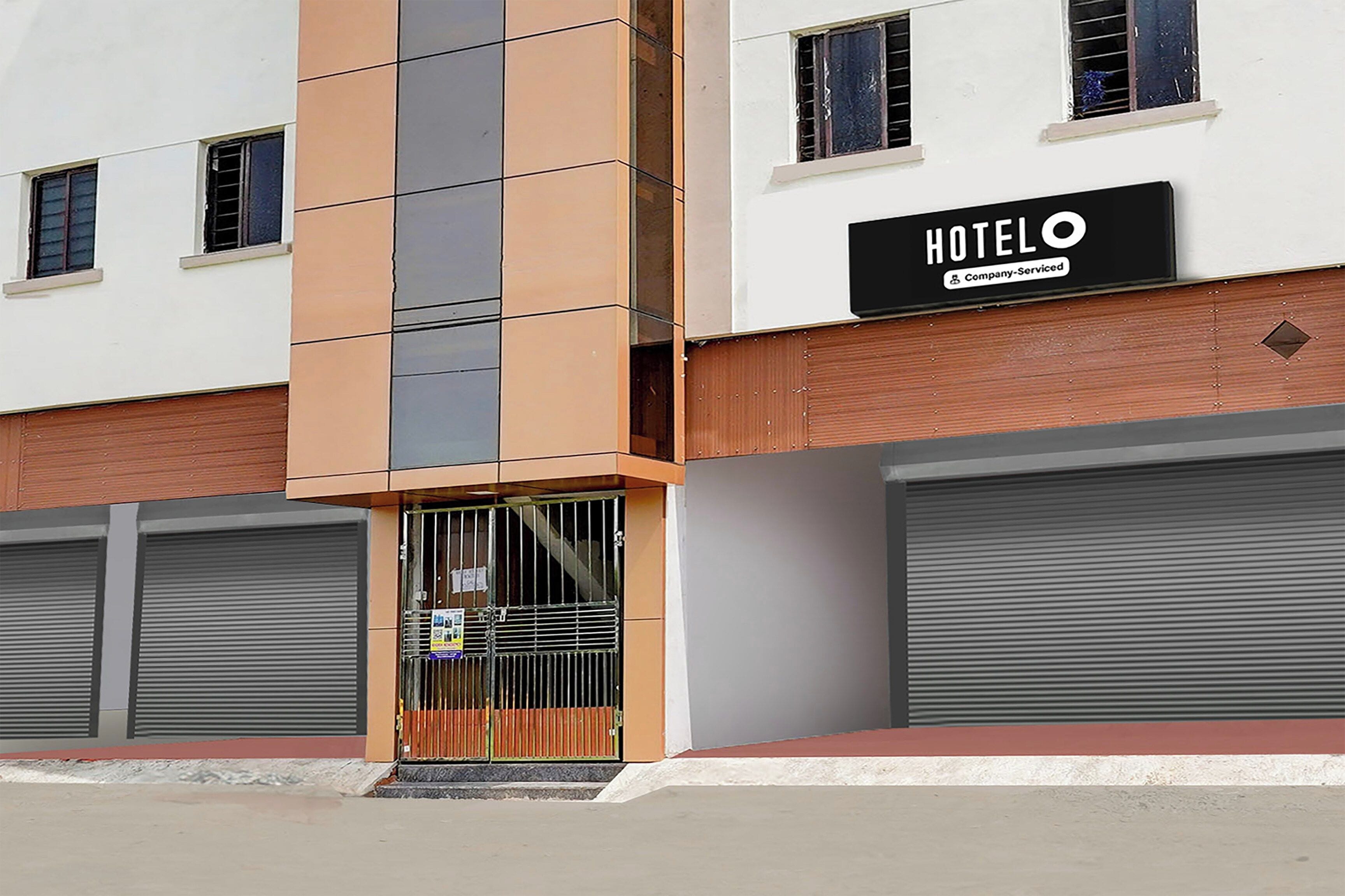 En hotels bygning med et skilt, der viser 'HOTELO Company-Serviced'.