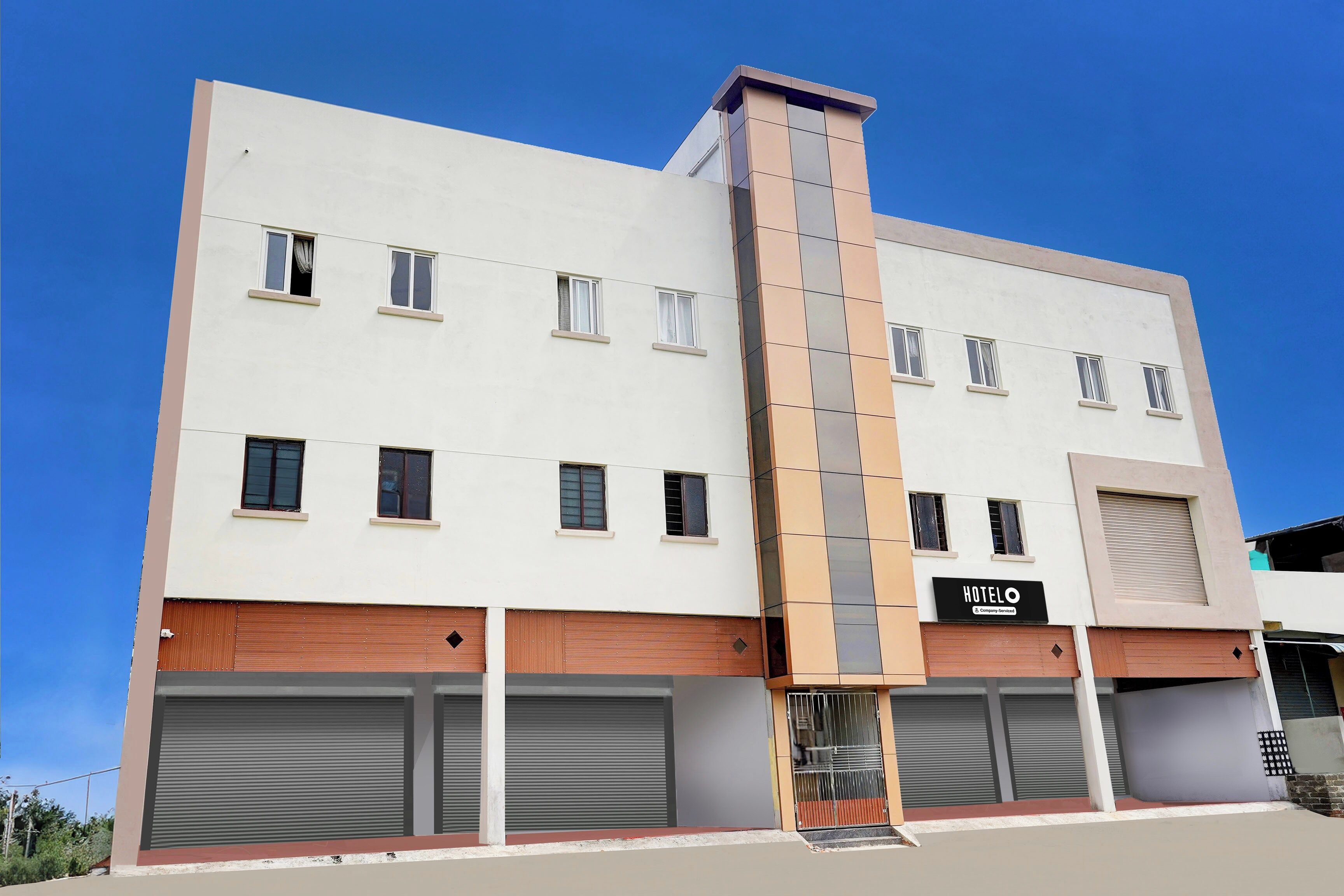 A modern hotel with a flat facade, multiple windows, and a prominent vertical feature.