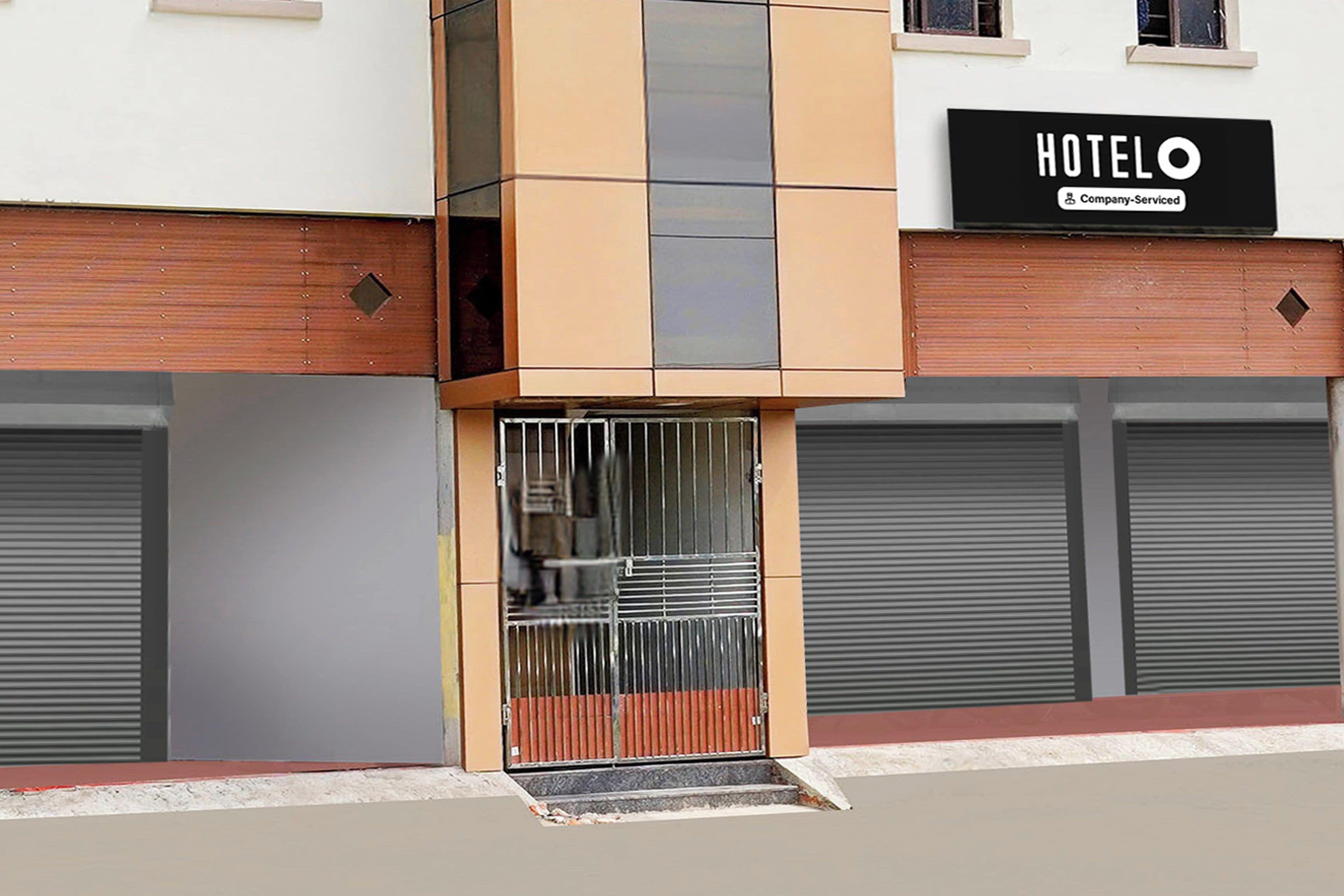 Entrada de un hotel con un cartel que indica servicio de empresa.