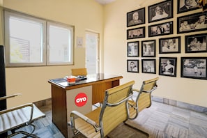 Ein Empfangsbereich mit einem Holztisch, einem roten Logo und einer Wand mit Schwarz-Weiß-Fotos.