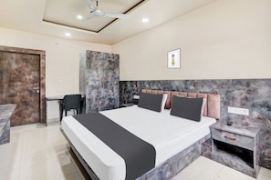 Une chambre à coucher moderne avec un grand lit, un bureau et une chaise.