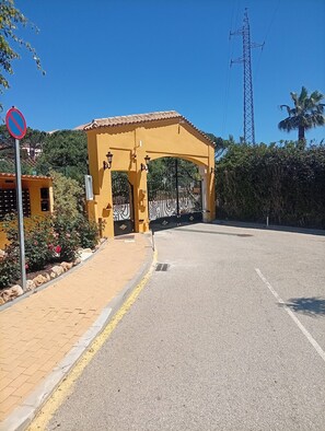 A gated entrance with a yellow archway, a no parking sign, and a clear sky. - Apartment 'Casa Kapano' with Mountain View, Wi-Fi and Air Conditioning (La Cala de Mijas)