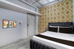 Une chambre à coucher avec un lit, une porte et trois œuvres d’art encadrées accrochées au mur.