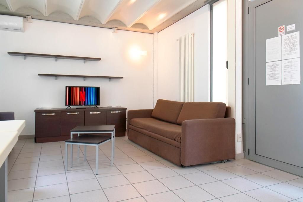 A modern living room with a sofa, a small table, a cabinet, and a television.