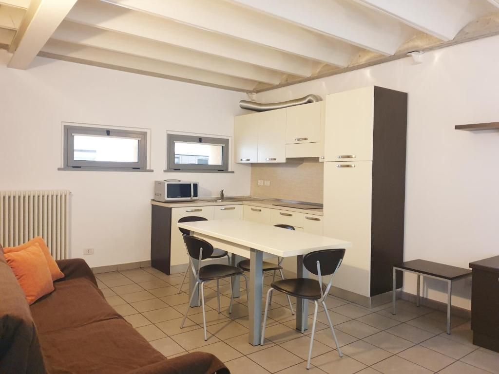 Una cocina funcional con comedor, un sofá y una pequeña mesa.