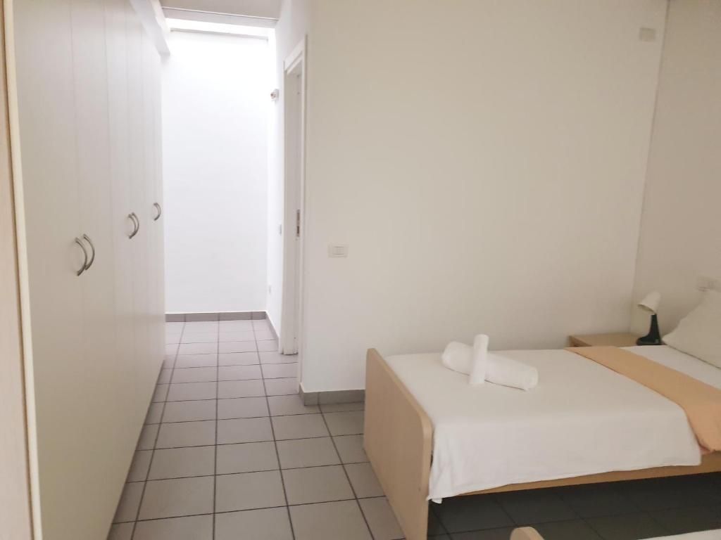 Un dormitorio con cama, mesita de noche y puerta que da a otra habitación.
