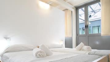 Una habitación de hotel con cama, ventana con vistas y puerta.