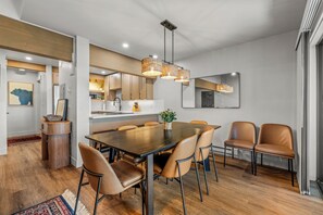 A modern dining area with a wooden table, leather chairs, and pendant lighting. - Sunrise 304 – Spacious Mountain Retreat Near Steamboat Resort! (Steamboat Springs)