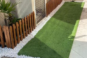 A section of a garden with artificial grass, a wooden fence, and a gravel border. - New Listing (São José dos Pinhais)