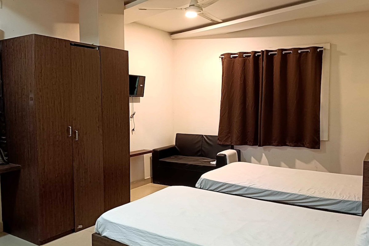 Un dormitorio con una cama, un armario, un escritorio, una silla y una ventana con cortinas.