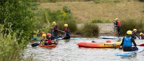 A group of people kayaking on a calm river.