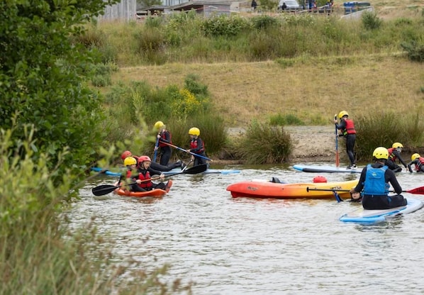 A group of people kayaking on a calm river.