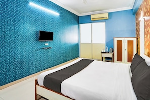 A hotel room with a bed, a television mounted on the wall, a wardrobe, and a window. - Super Hotel O Vibrant Residency (Ahmedabad)