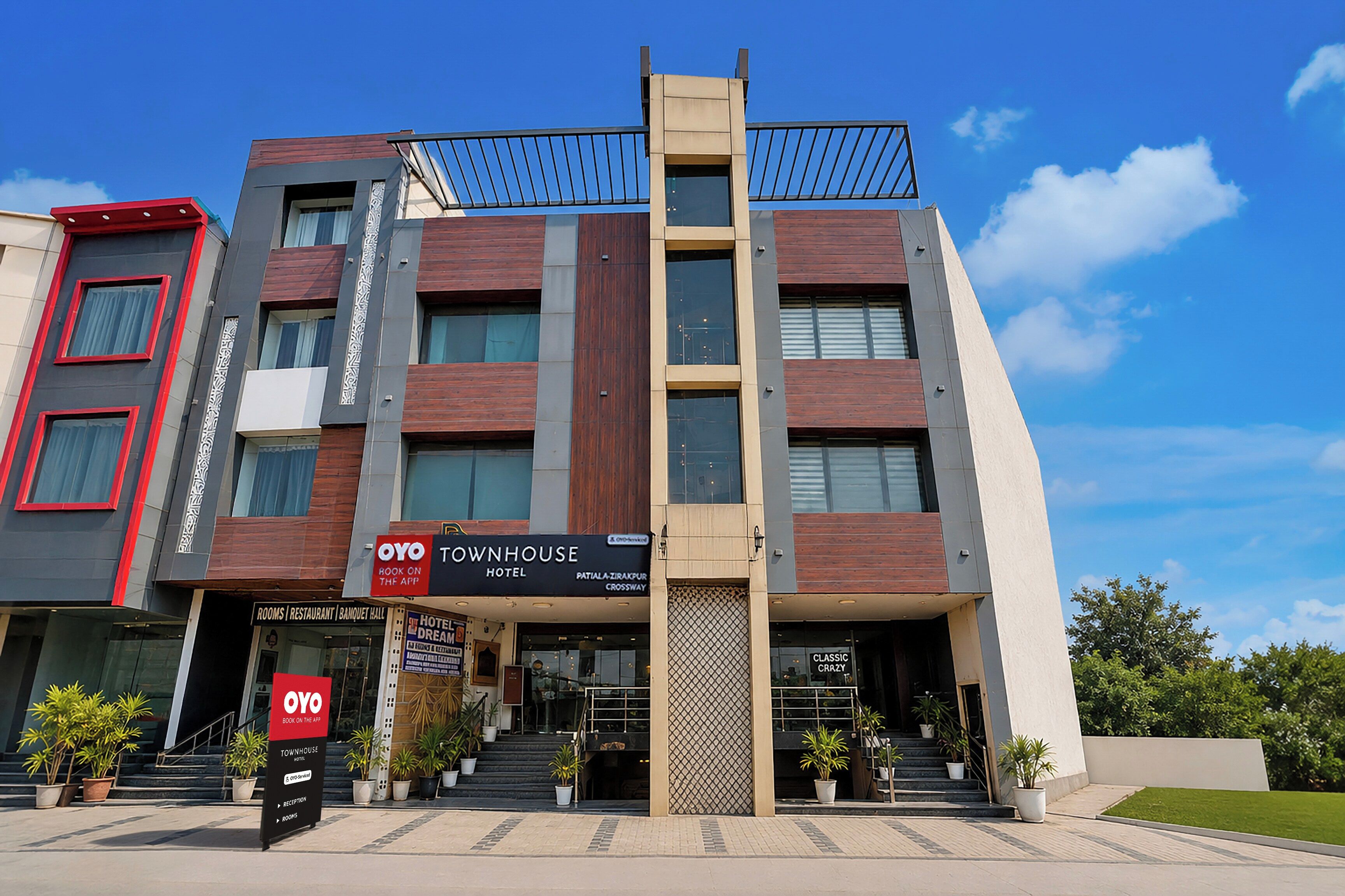Un hotel moderno con fachada vertical, varios balcones y una entrada destacada con escalones.