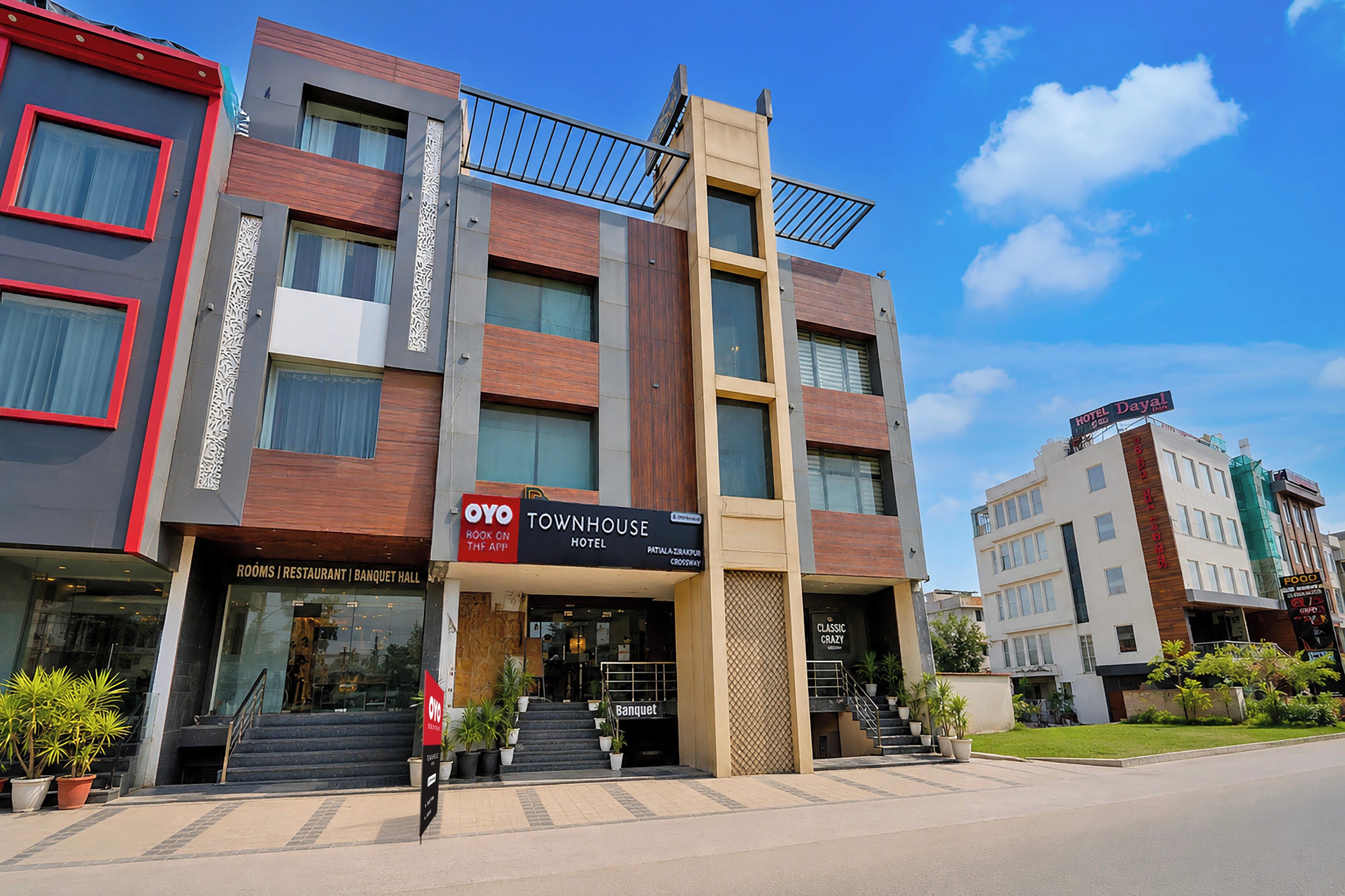 Um hotel com vários andares e fachada moderna, com destaque para a placa do OYO Townhouse Hotel.
