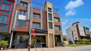 Um hotel com vários andares e fachada moderna, com destaque para a placa do OYO Townhouse Hotel.