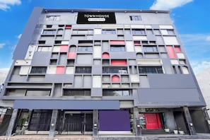 A multi-story building with a sign reading 'TOWNHOUSE Company Serviced'.