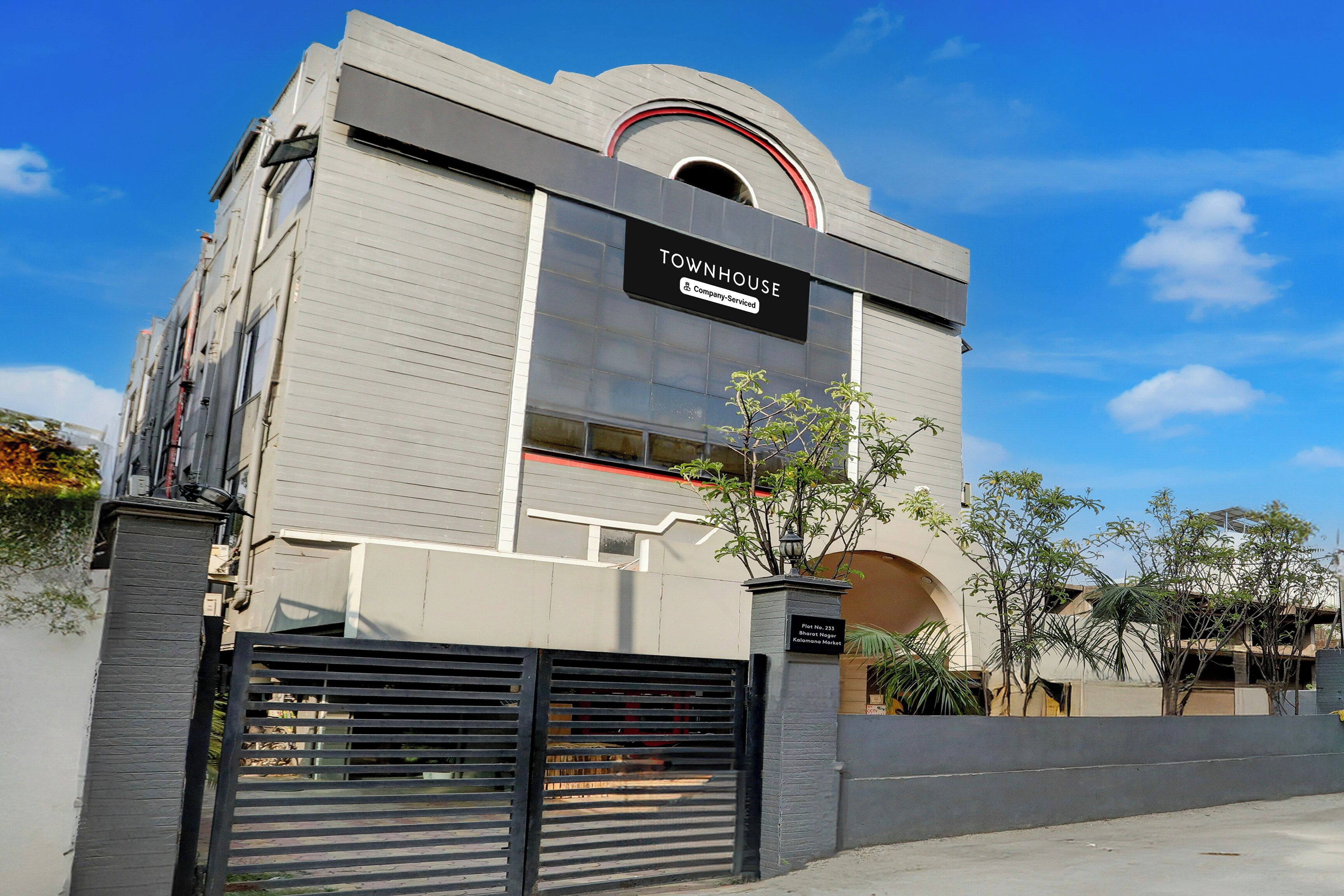 A modern building with a sign indicating it is a company-serviced townhouse.