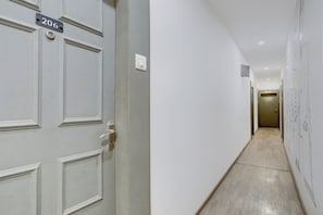 A hallway with a door labeled '206' and a light switch on the wall. - Townhouse Kalmana (Nagpur)
