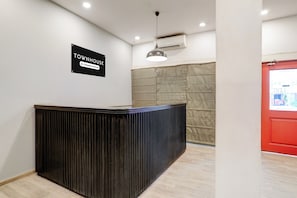 A reception desk with a sign indicating it is company-serviced. - Townhouse Kalmana (Nagpur)