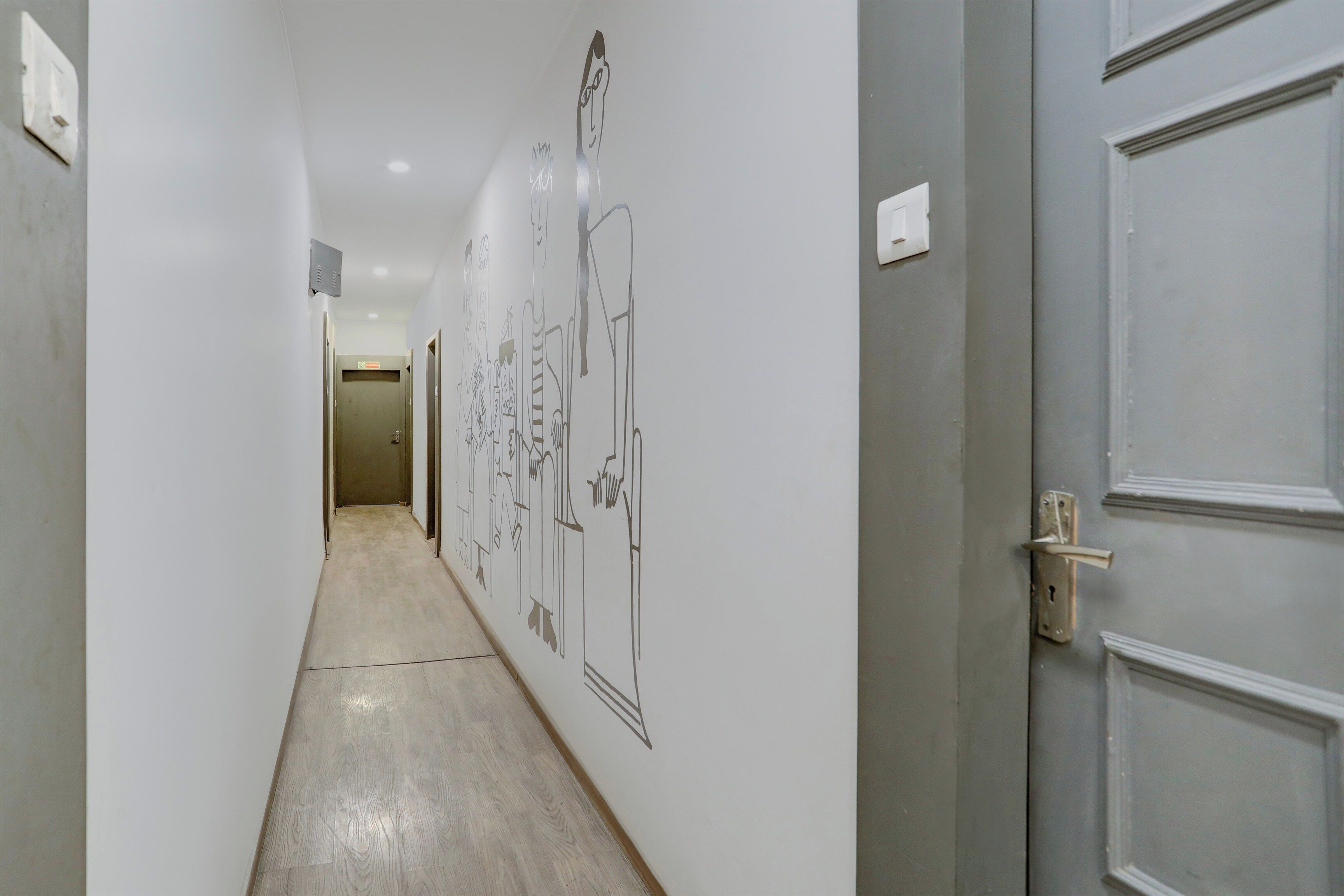 A hallway with a light-colored floor, white walls, and doors on both sides.