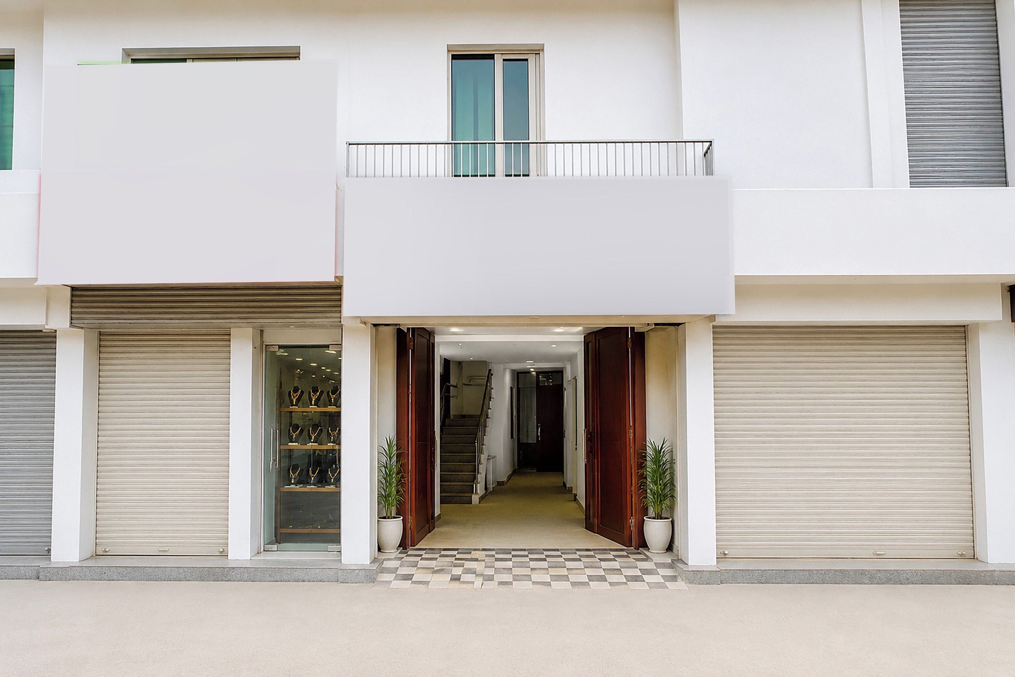 A multi-story building with a central entrance, a staircase, and two balconies.