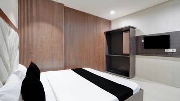 A modern bedroom with a bed, a wardrobe, and a TV mounted on the wall.