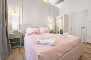 A bedroom with a bed, bedside tables, a wardrobe, and a mirror. - Nuraghi (Il-Furjana)