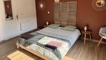Ein Schlafzimmer mit einem Bett, zwei Nachttischen, einem Spiegel, einer Heizung und einer Tür.