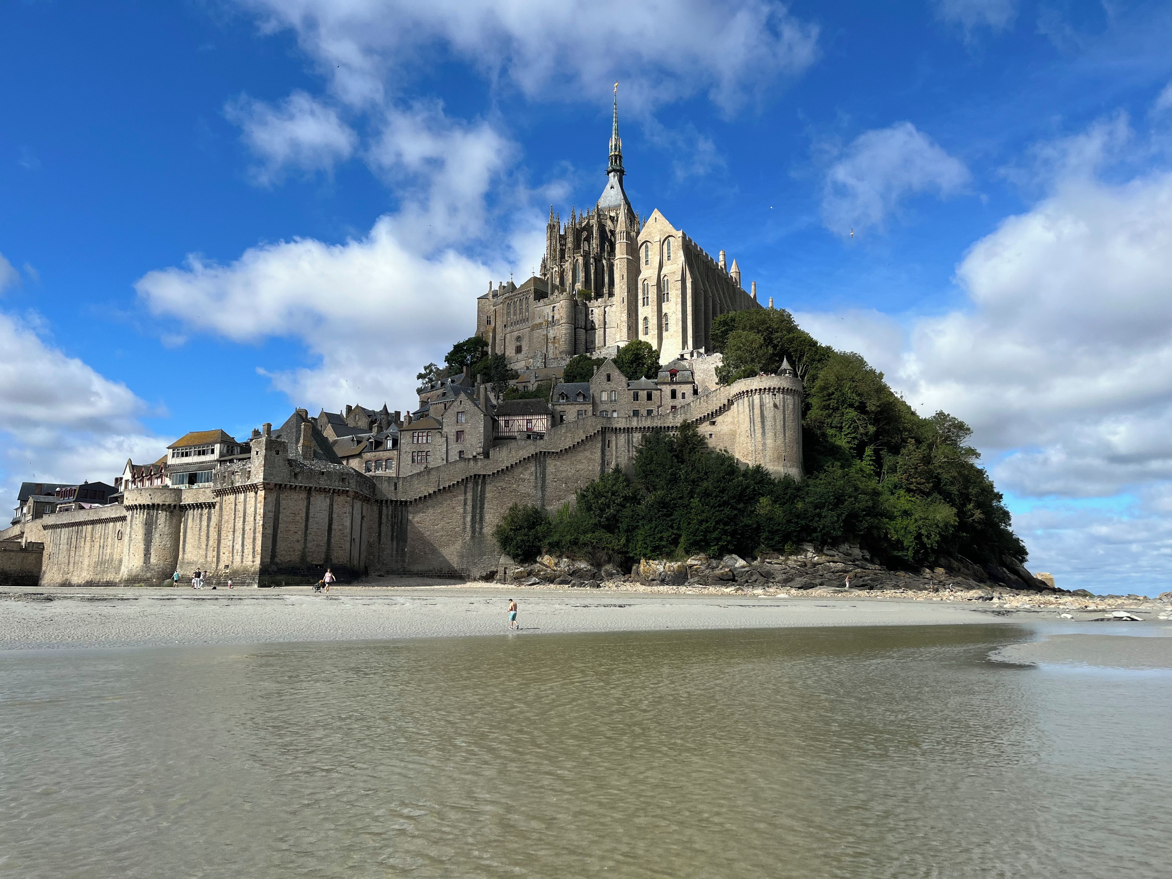 Un château historique perché sur une colline, d’où l’on a vue sur une plage.