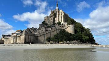 Eine historische Burg auf einem Hügel mit Blick auf einen Strand.