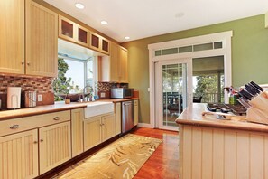 A kitchen with wooden cabinets, a built-in microwave, and a gas stove. - Kona Mountain Home - Quiet 3 acre property minutes from Beaches and Kailua (Kailua-Kona)