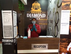 Mostrador de recepción en el Hotel Diamond Star, con un cartel que indica la zona de recepción.