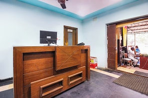 A reception desk with a flat-screen TV, a wooden counter, and a door labeled 'Family Section.' - Hotel O Sai Residency (Hyderabad)